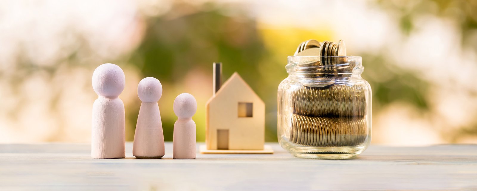 family figures with model house and jar of money